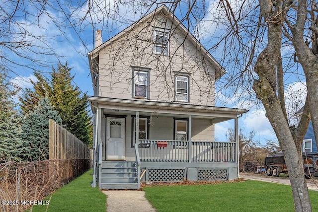 view of front of house featuring a porch, fence, and a front yard