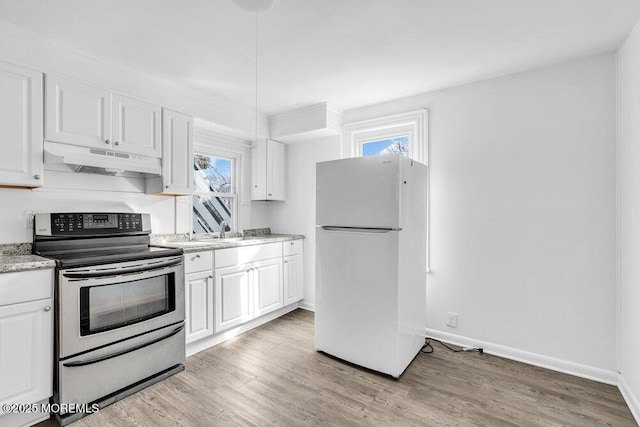 kitchen featuring freestanding refrigerator, stainless steel electric range oven, under cabinet range hood, and white cabinets