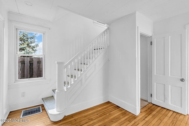 stairs featuring visible vents, baseboards, and hardwood / wood-style floors