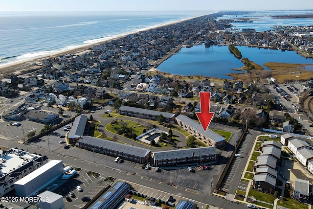 drone / aerial view with a water view and a beach view