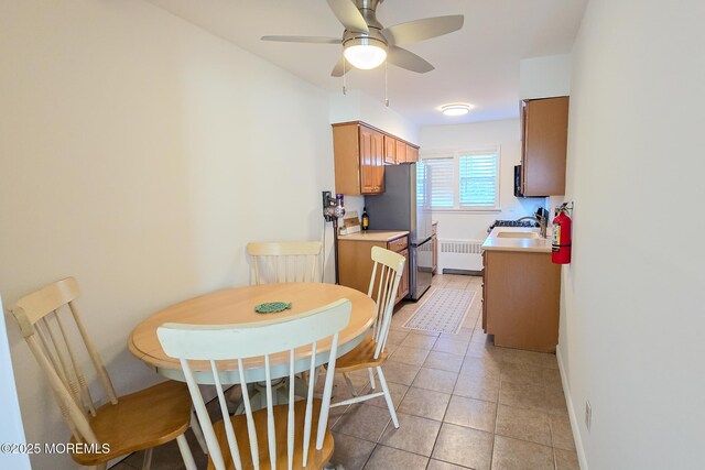 dining space with light tile patterned floors, radiator heating unit, and ceiling fan