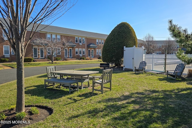 view of property's community featuring a gate, a yard, and fence