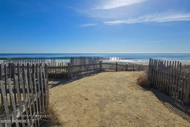 exterior space with fence and a view of the beach