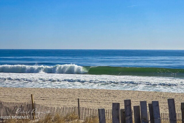view of water feature with a view of the beach and fence