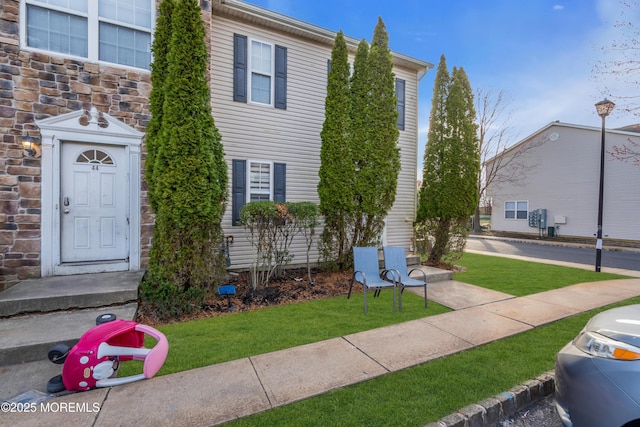 view of front facade featuring a front yard and stone siding