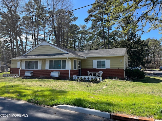 view of front of home featuring brick siding and a front yard