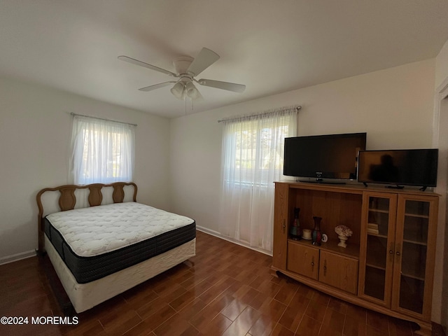 bedroom featuring dark wood-type flooring, baseboards, and ceiling fan