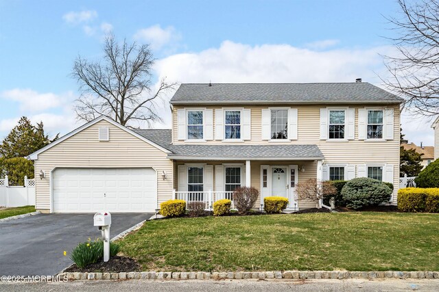 view of front facade with a front lawn, aphalt driveway, a porch, roof with shingles, and a garage