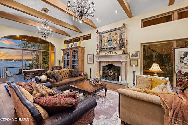 living area with wood finished floors, an inviting chandelier, beamed ceiling, and a premium fireplace