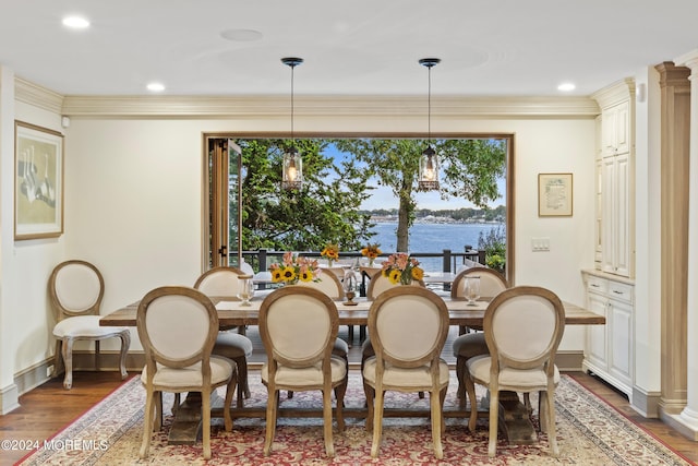 dining area featuring a water view, crown molding, wood finished floors, recessed lighting, and an inviting chandelier