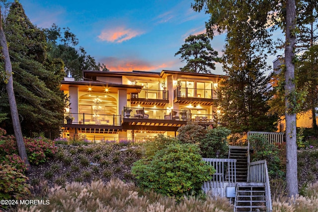 back of property with a balcony and stairway