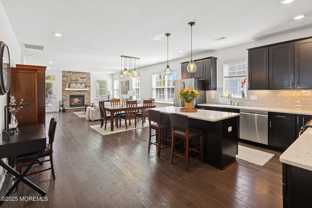 kitchen featuring tasteful backsplash, visible vents, a center island, a breakfast bar, and stainless steel appliances