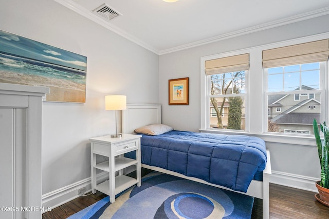 bedroom featuring wood finished floors, visible vents, baseboards, and ornamental molding
