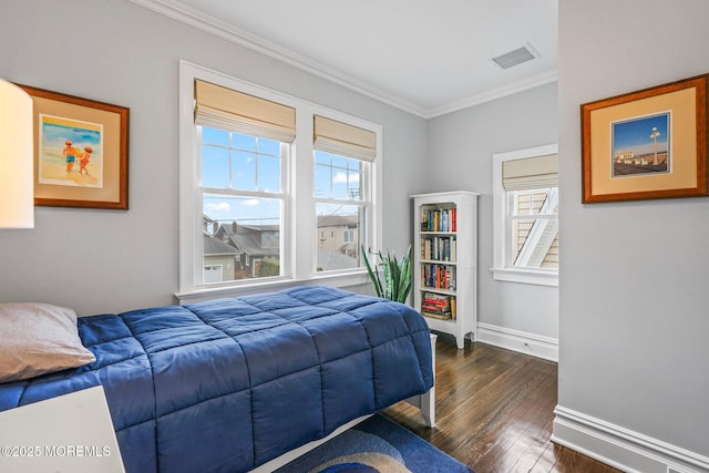 bedroom with dark wood-style floors, crown molding, multiple windows, and visible vents