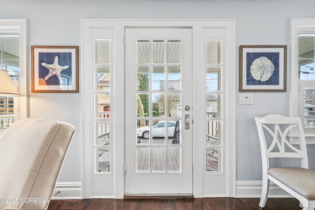 doorway to outside with baseboards and dark wood finished floors