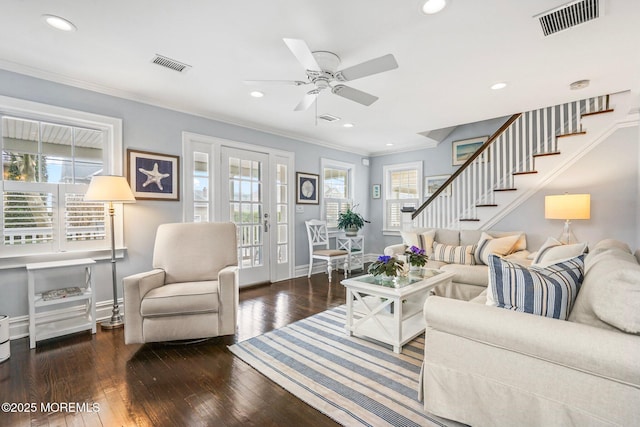 living room with ceiling fan, ornamental molding, stairs, and visible vents