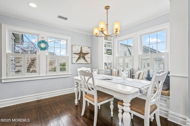 dining space featuring hardwood / wood-style floors, ornamental molding, baseboards, a notable chandelier, and visible vents