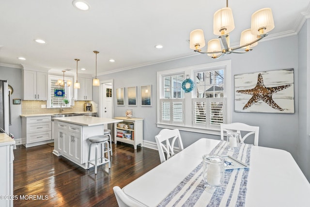dining area featuring dark wood finished floors, crown molding, and a chandelier