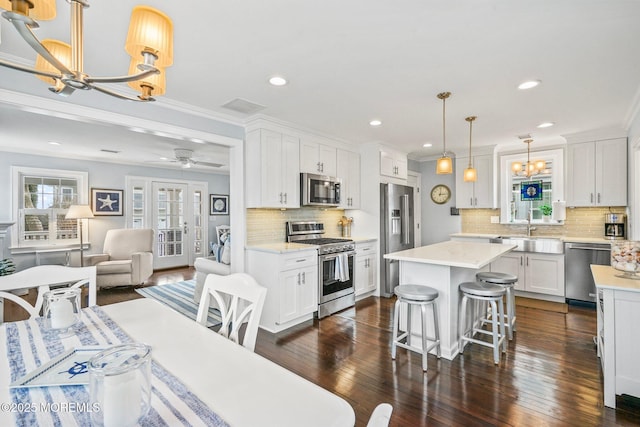 kitchen featuring a center island, a sink, visible vents, an inviting chandelier, and appliances with stainless steel finishes