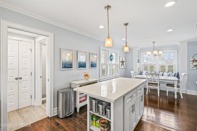 kitchen with baseboards, an inviting chandelier, dark wood-style floors, and ornamental molding