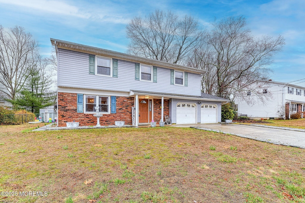 view of front facade featuring fence, driveway, a front lawn, brick siding, and a garage