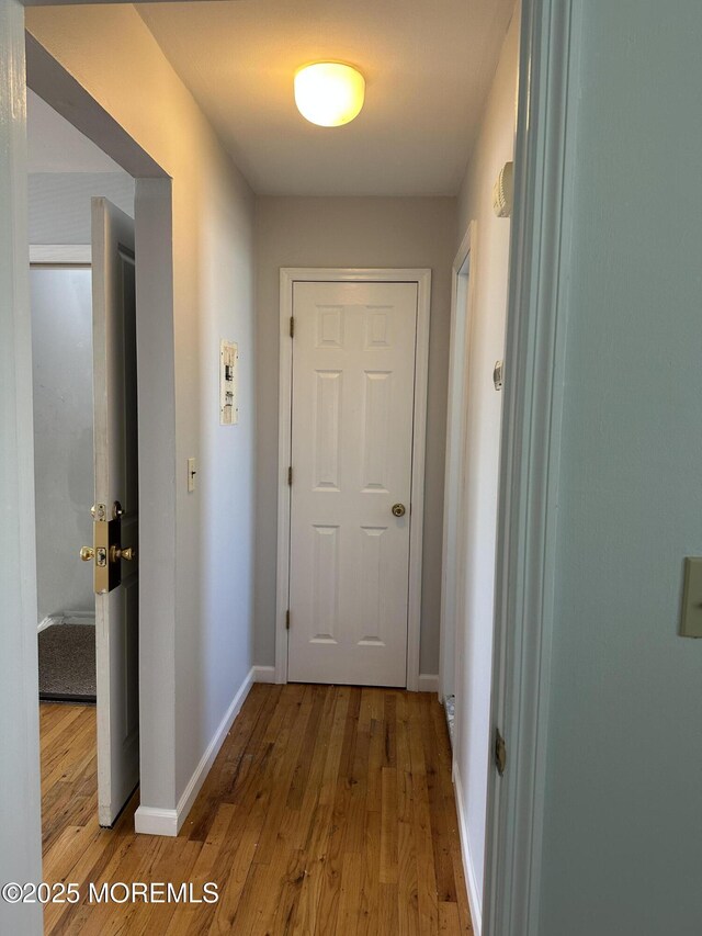 hallway featuring wood finished floors and baseboards