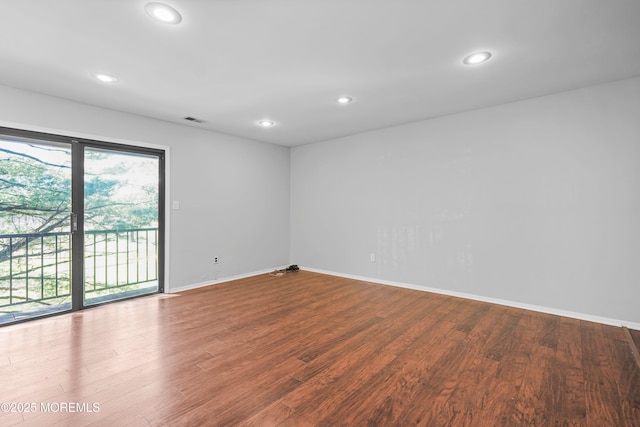 spare room with wood finished floors, baseboards, visible vents, and recessed lighting