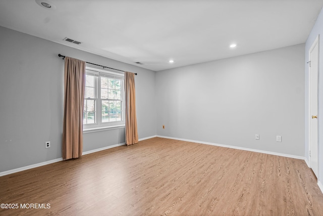 unfurnished room featuring light wood-style floors, baseboards, visible vents, and recessed lighting