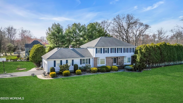 view of front of home with concrete driveway and a front yard