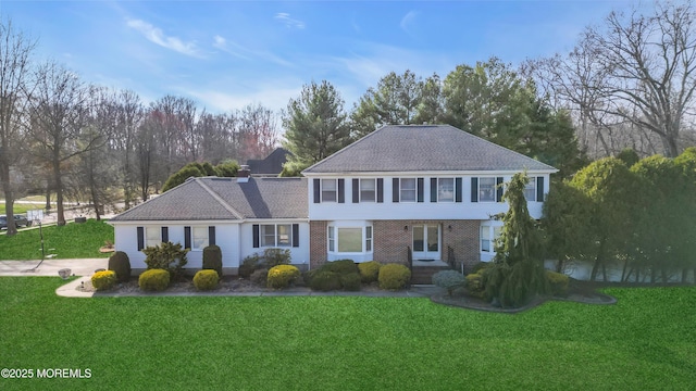 view of front of house featuring a front lawn and brick siding