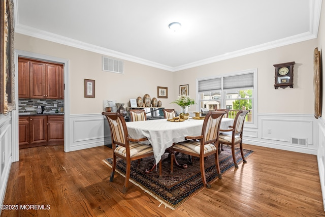4 Friendship Ln, West Long Branch, NJ 07764 - dining area with crown molding, dark wood-type flooring, a wainscoted wall, and a decorative wall