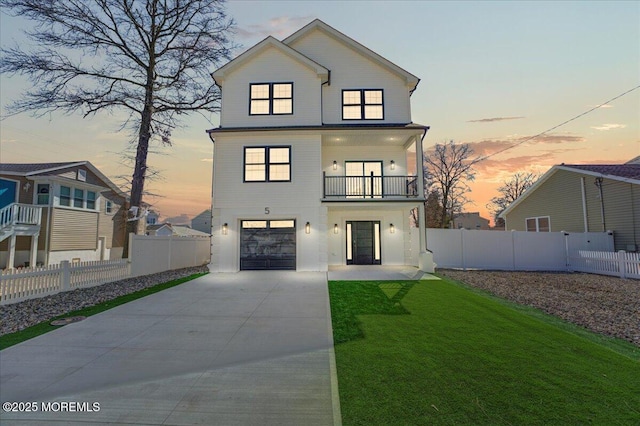 view of front facade featuring concrete driveway, fence, a balcony, a lawn, and a garage