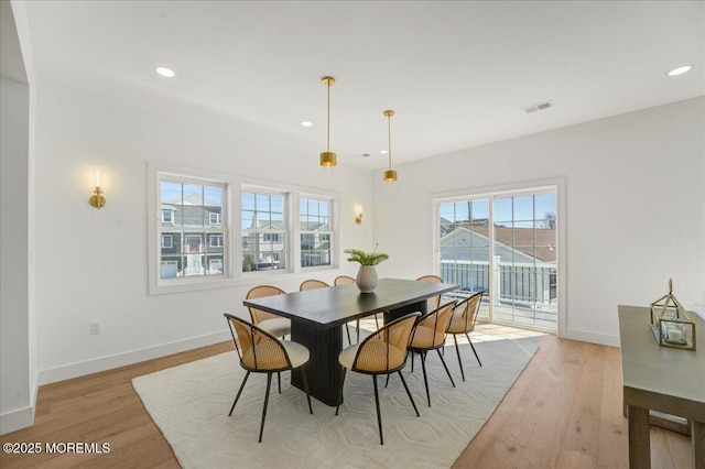 dining space with baseboards, light wood finished floors, and recessed lighting