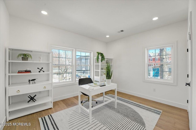 home office with plenty of natural light, visible vents, and light wood-style flooring