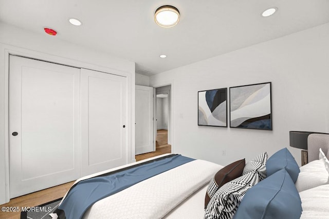 bedroom featuring a closet, light wood-style flooring, and recessed lighting