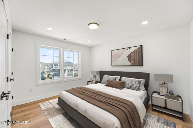 bedroom featuring light wood finished floors, baseboards, visible vents, and recessed lighting