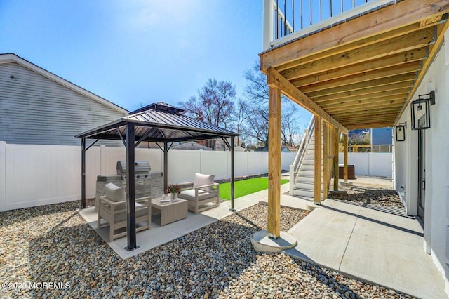 view of patio with a fenced backyard, grilling area, a gazebo, and stairway