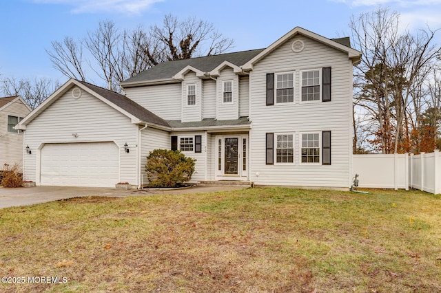 traditional-style house featuring driveway, a garage, fence, and a front yard