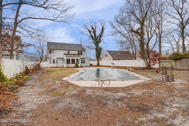 back of property with a fenced backyard and a patio