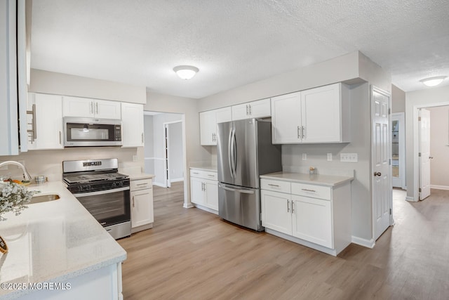 kitchen with a sink, white cabinetry, and appliances with stainless steel finishes