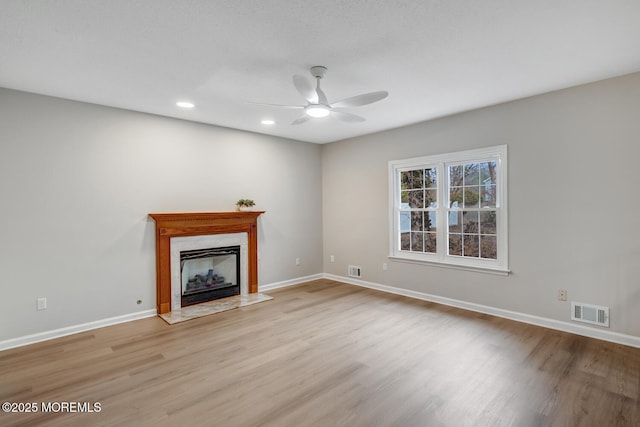 unfurnished living room featuring baseboards, light wood-style flooring, ceiling fan, and visible vents