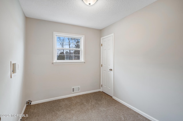 spare room with baseboards, visible vents, carpet flooring, and a textured ceiling