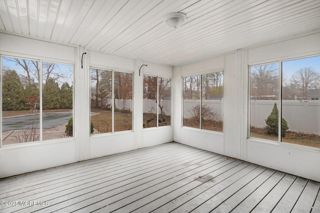 unfurnished sunroom featuring plenty of natural light, a deck, and hardwood / wood-style flooring