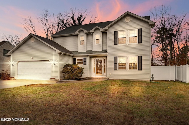 traditional-style home featuring a lawn, a garage, fence, and concrete driveway