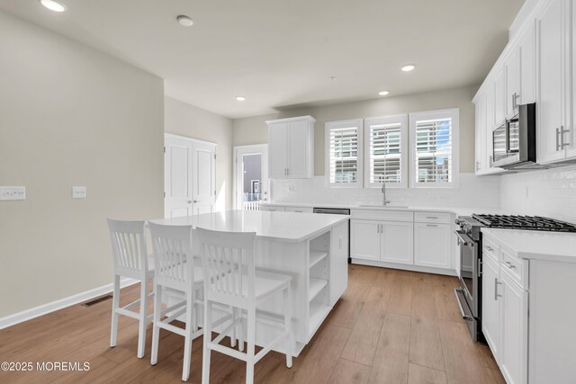 75 Driftwood Cir, Oceanport, NJ 07757 - kitchen with stainless steel appliances, open shelves, decorative backsplash, and a sink