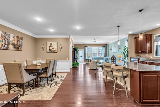 dining space featuring a wainscoted wall, recessed lighting, crown molding, and wood finished floors