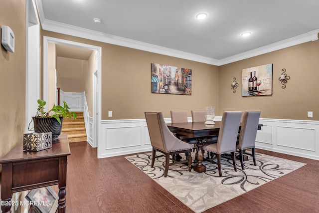 dining room featuring dark wood-style floors, ornamental molding, and wainscoting