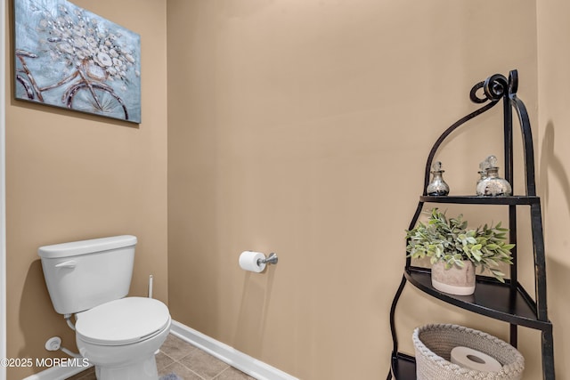 bathroom with baseboards, toilet, and tile patterned flooring