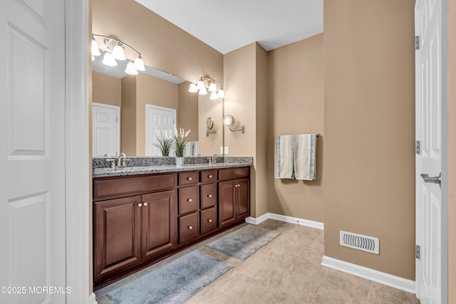 full bath featuring a sink, tile patterned flooring, baseboards, visible vents, and double vanity