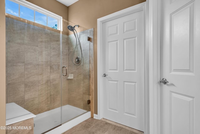 bathroom with a stall shower and tile patterned flooring